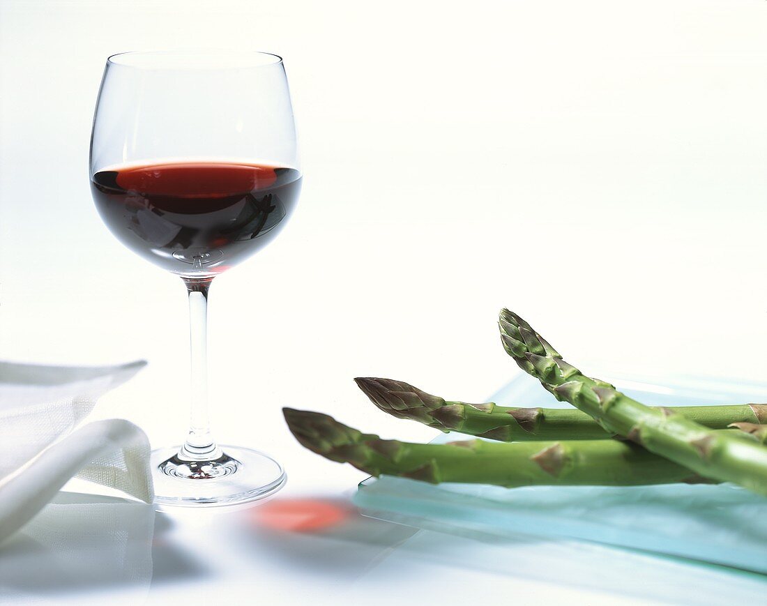 Grüne Spargelstangen und ein Glas Rotwein