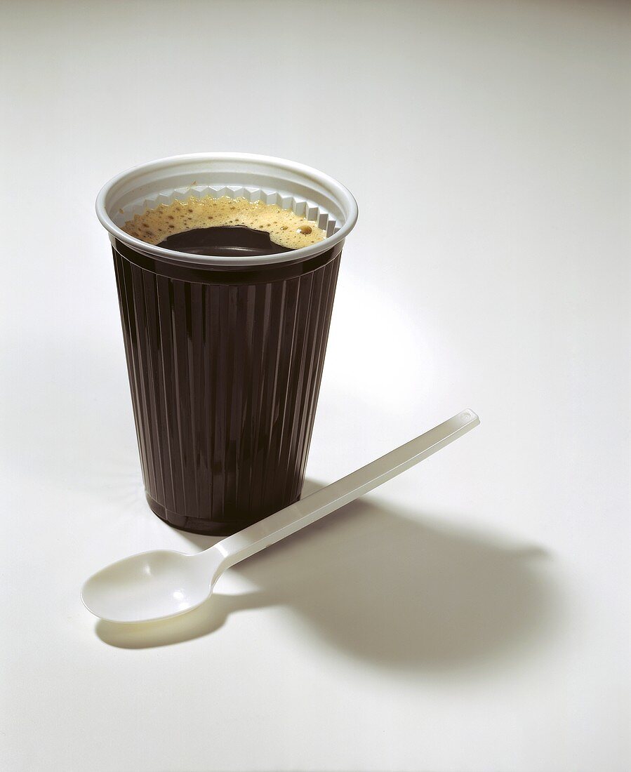 Coffee to go: coffee in plastic cup, plastic spoon