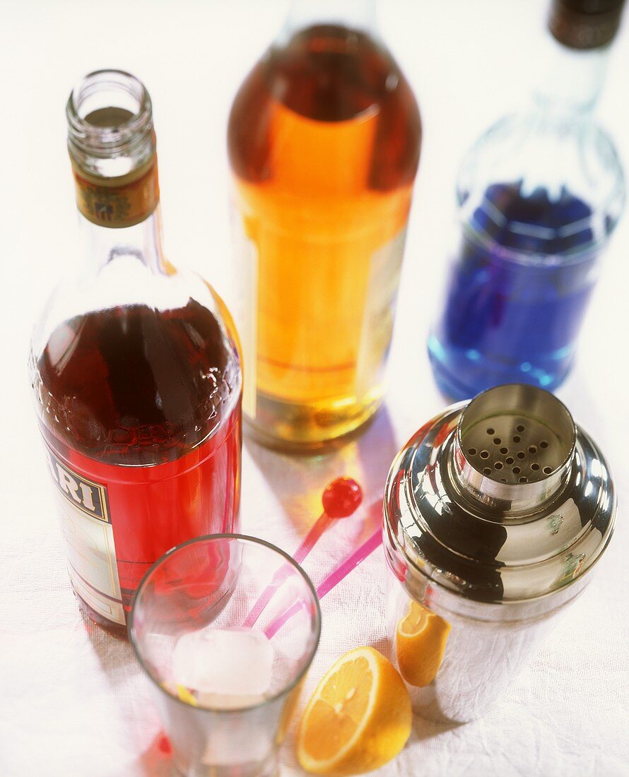 Cocktail still life: highly coloured liqueurs, shaker & glass