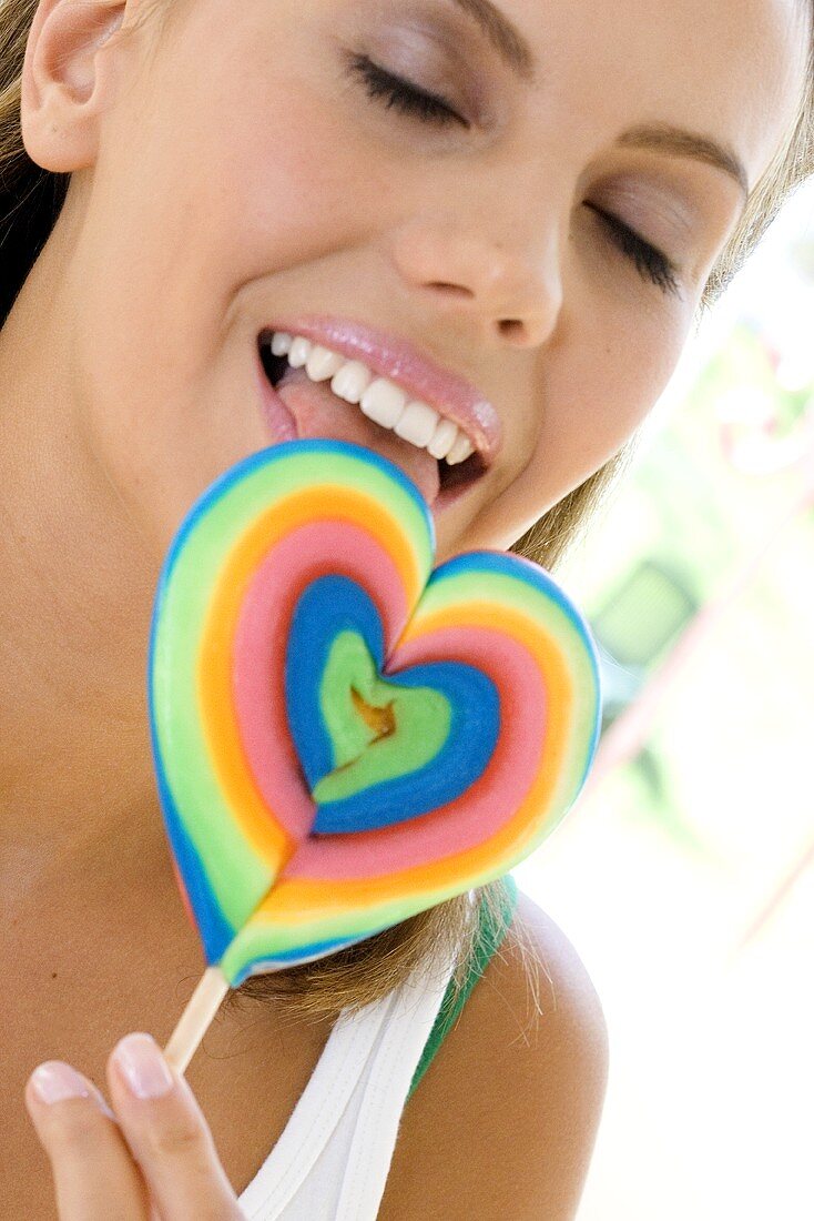 Young woman licking a lollipop