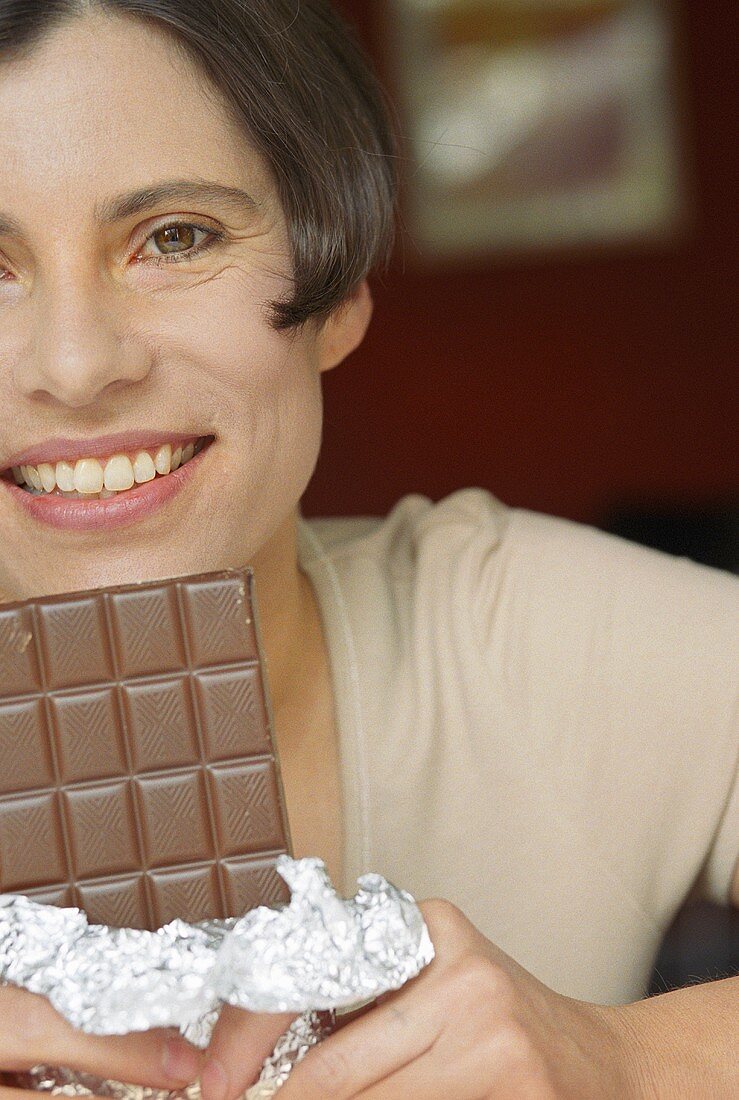 Frau hält eine Tafel Schokolade
