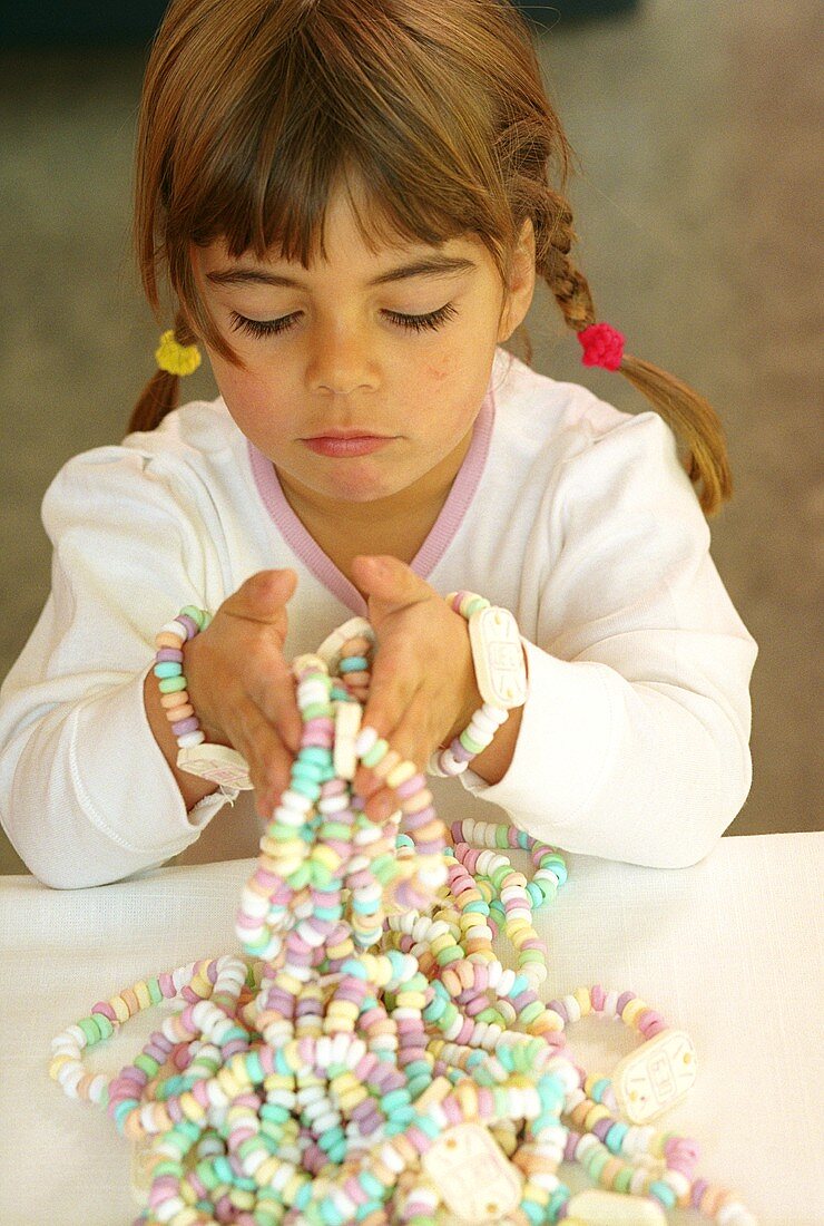 Kleines Mädchen mit Bonbonkette