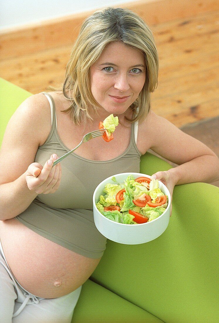 Schwangere Frau isst gesunden Salat