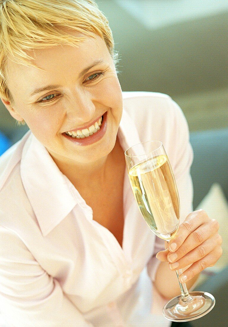 Blonde Frau hält Glas Sekt