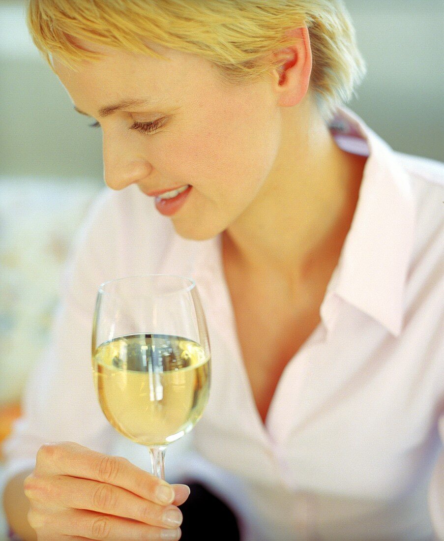 Blonde Frau mit einem Glas Weißwein