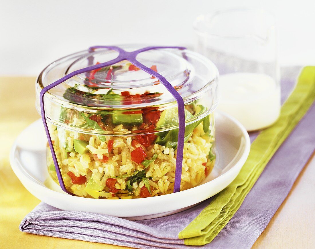 Rice and avocado salad in glass bowl