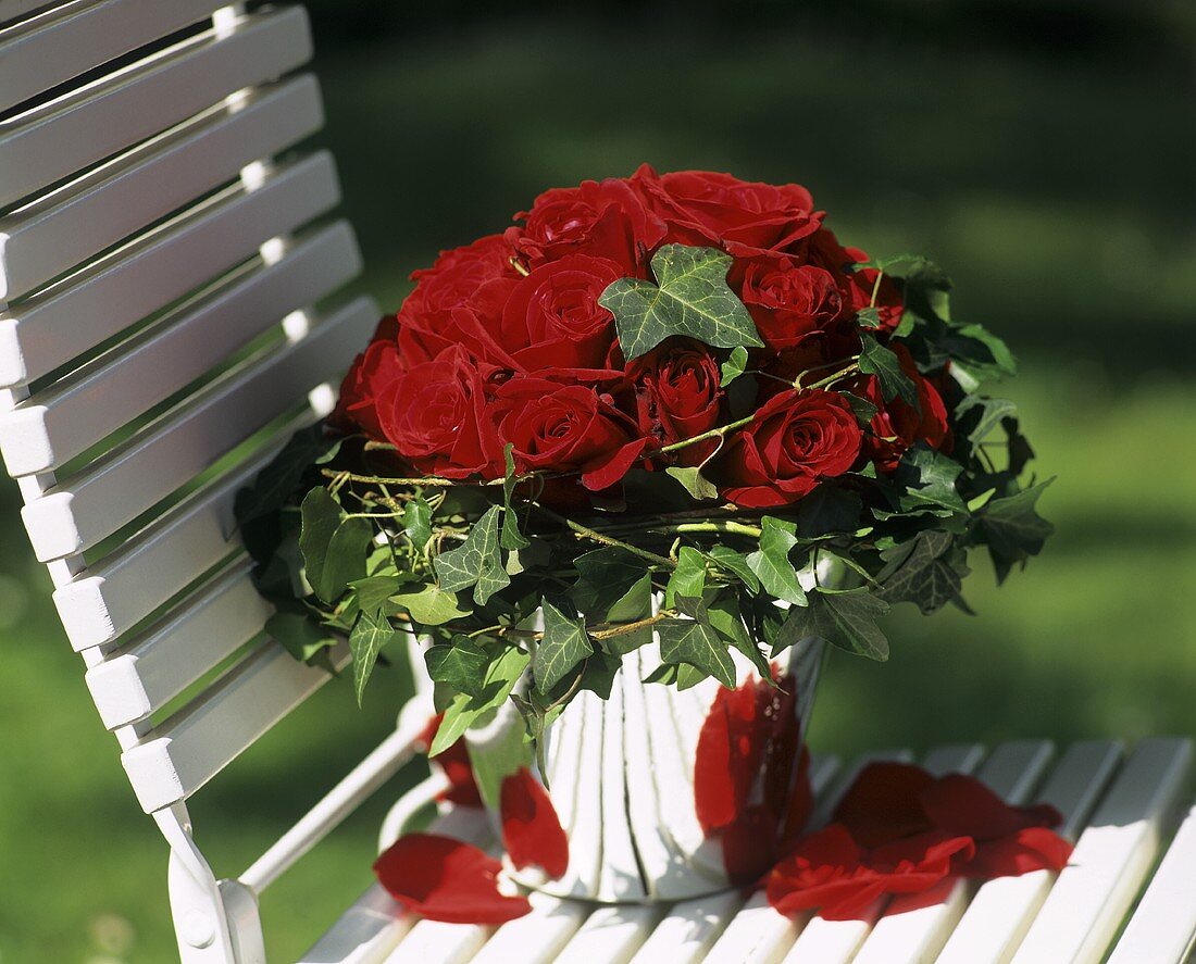Bouquet of red roses on a garden chair