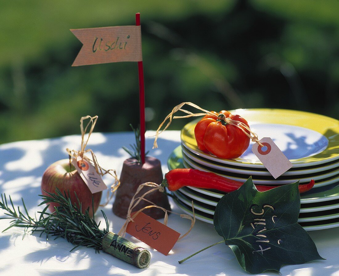 Imaginative place-cards on apple, pepper, rosemary etc.