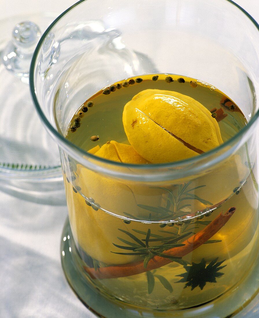 Eingelegte Zitronen mit Gewürzen und Kräutern im Glas