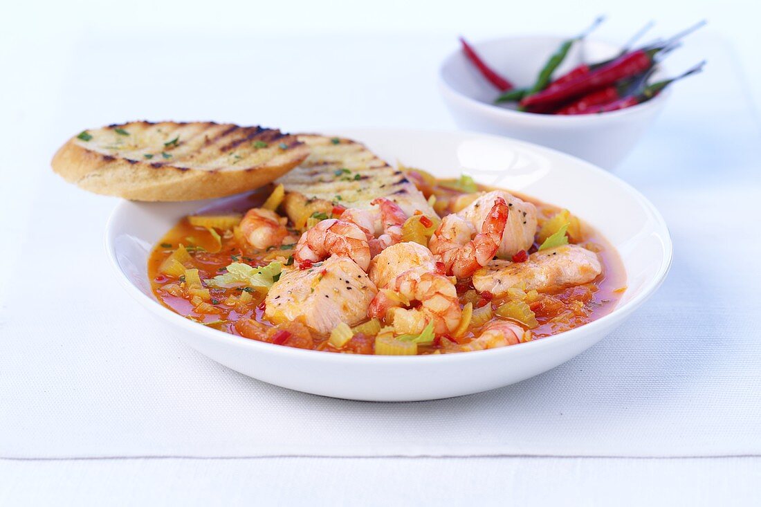 Fish and shrimp stew and toasted baguette slices