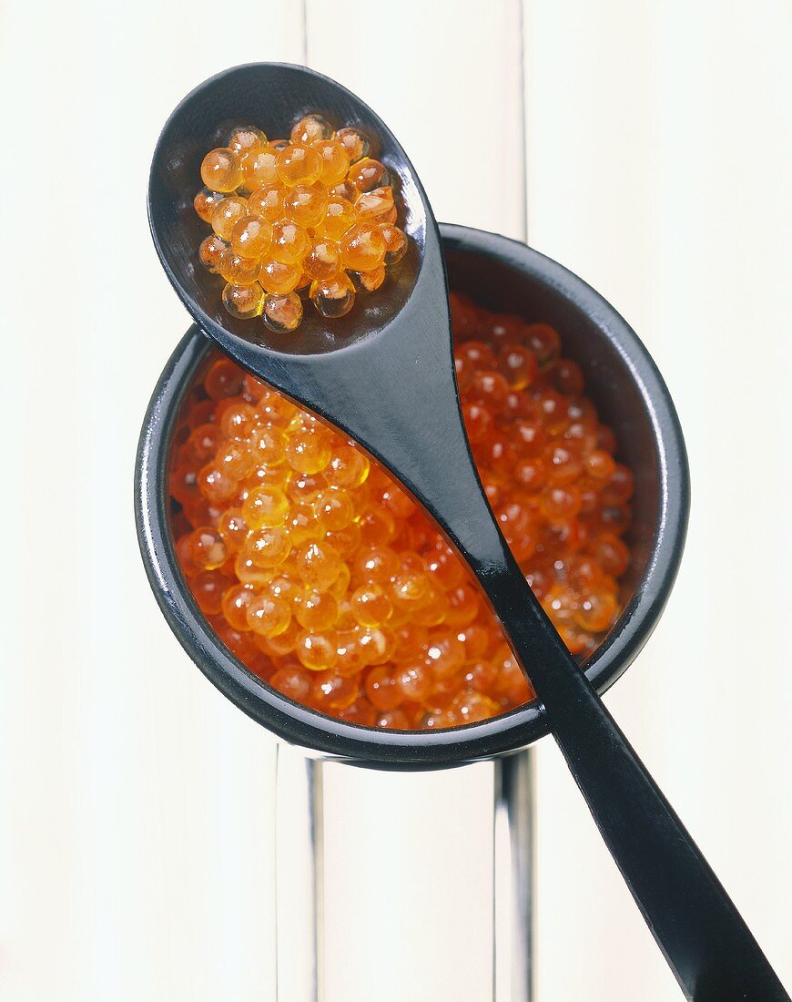 Roter Kaviar im Schälchen und auf Löffel
