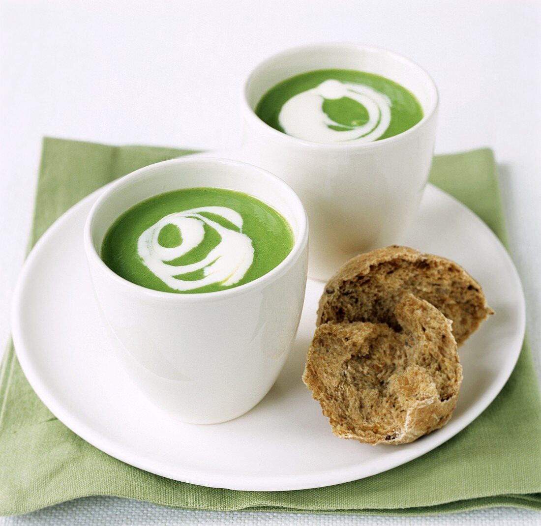 Pea soup with crème fraiche in beakers; wholemeal roll