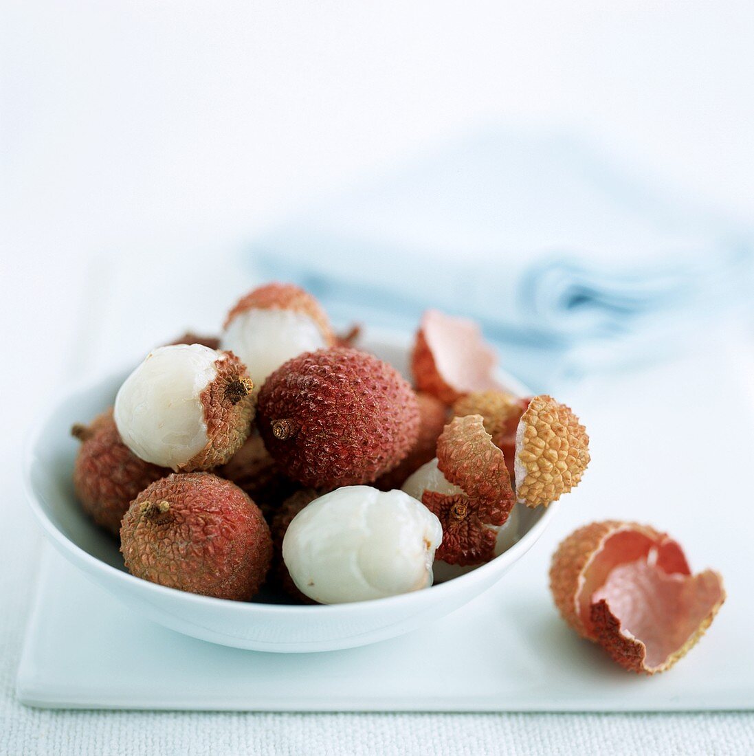 Lychees, teilweise geschält in einem Schälchen