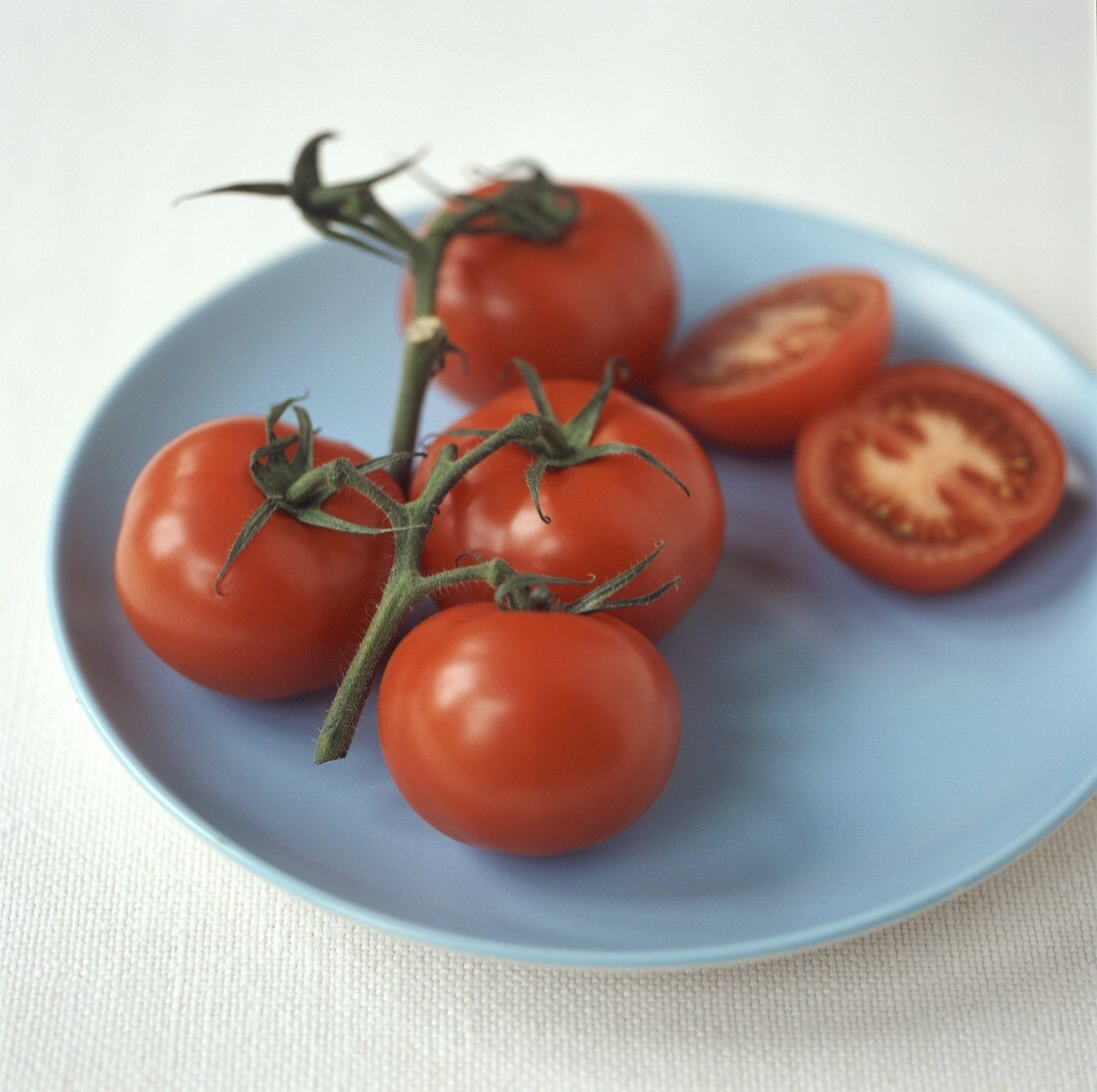 Tomatoes on the vine, one cut open