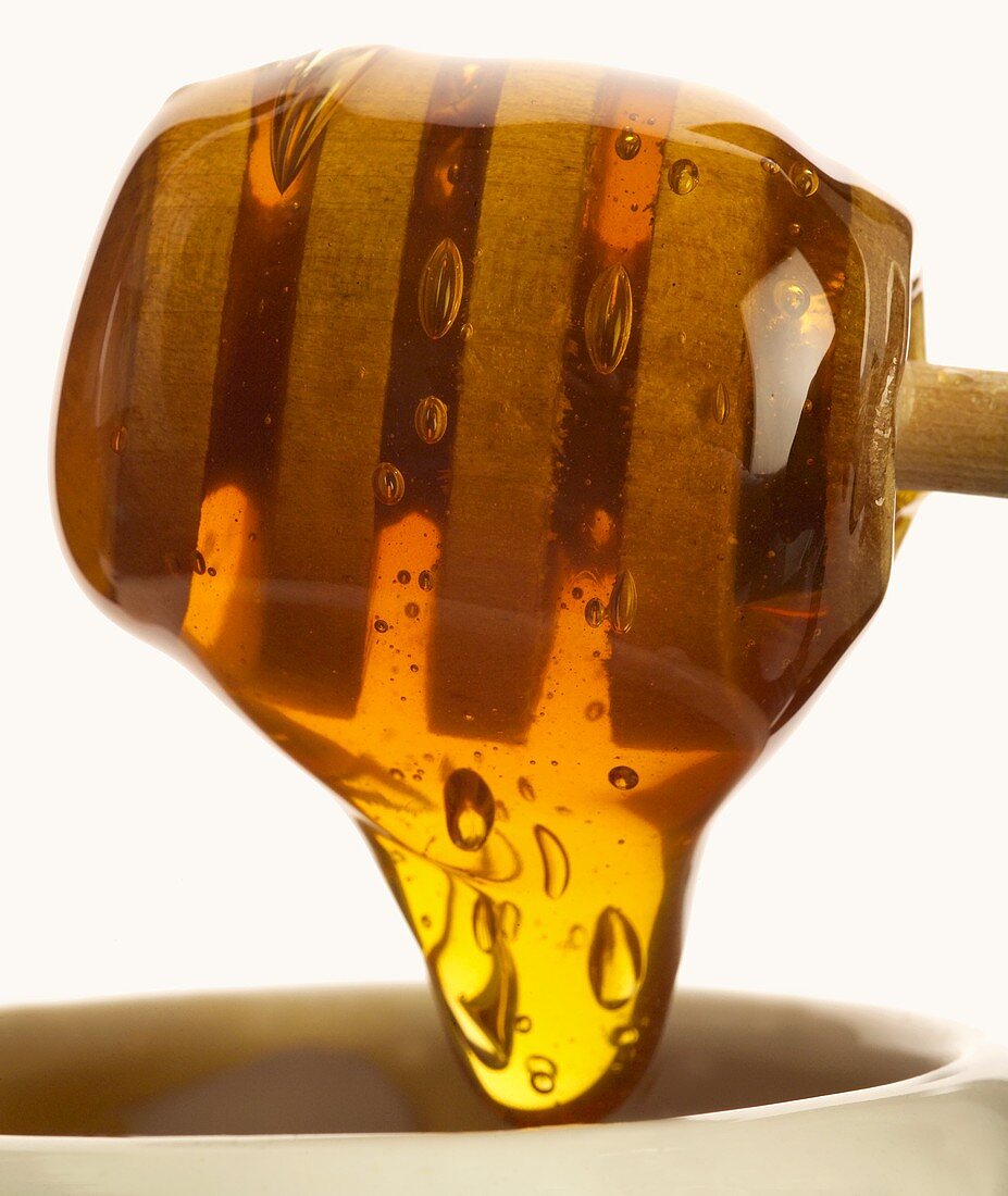 Honey running from a honey dipper (close-up)