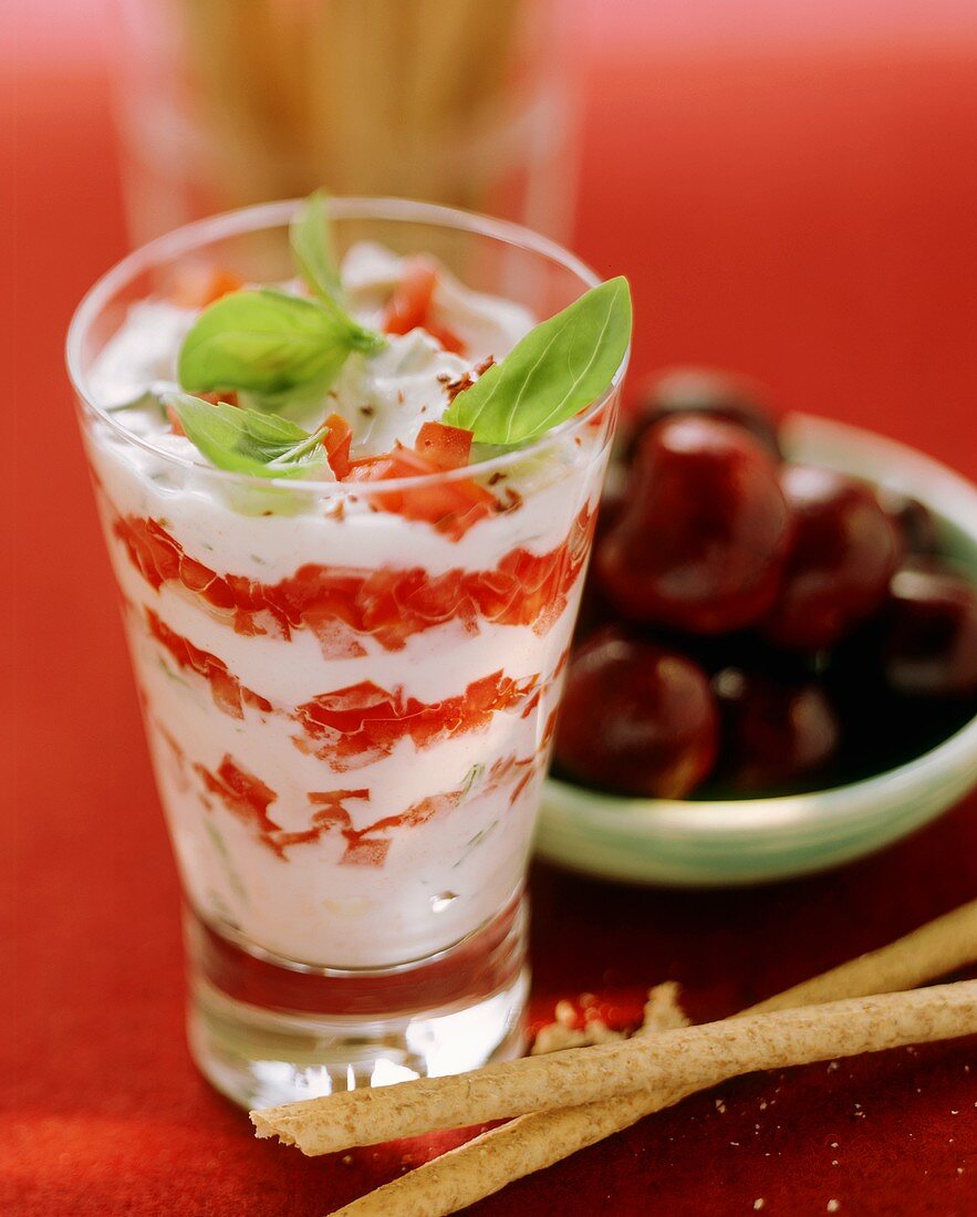 Tomato salad with yoghurt in glass with grissini