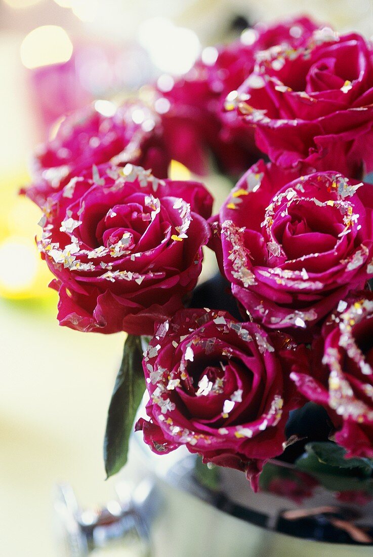 Red roses sprinkled with flecks of silver in a champagne bucket