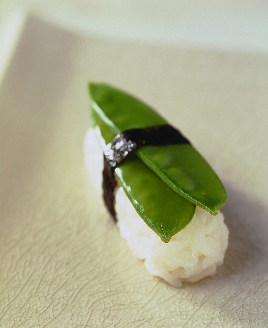 A nigiri-sushi with mangetout peas