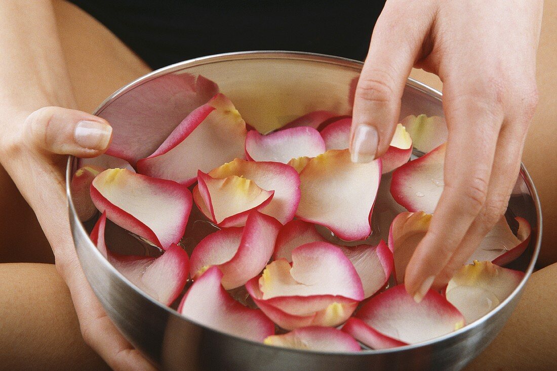 Hand hält Schüssel mit Blüten