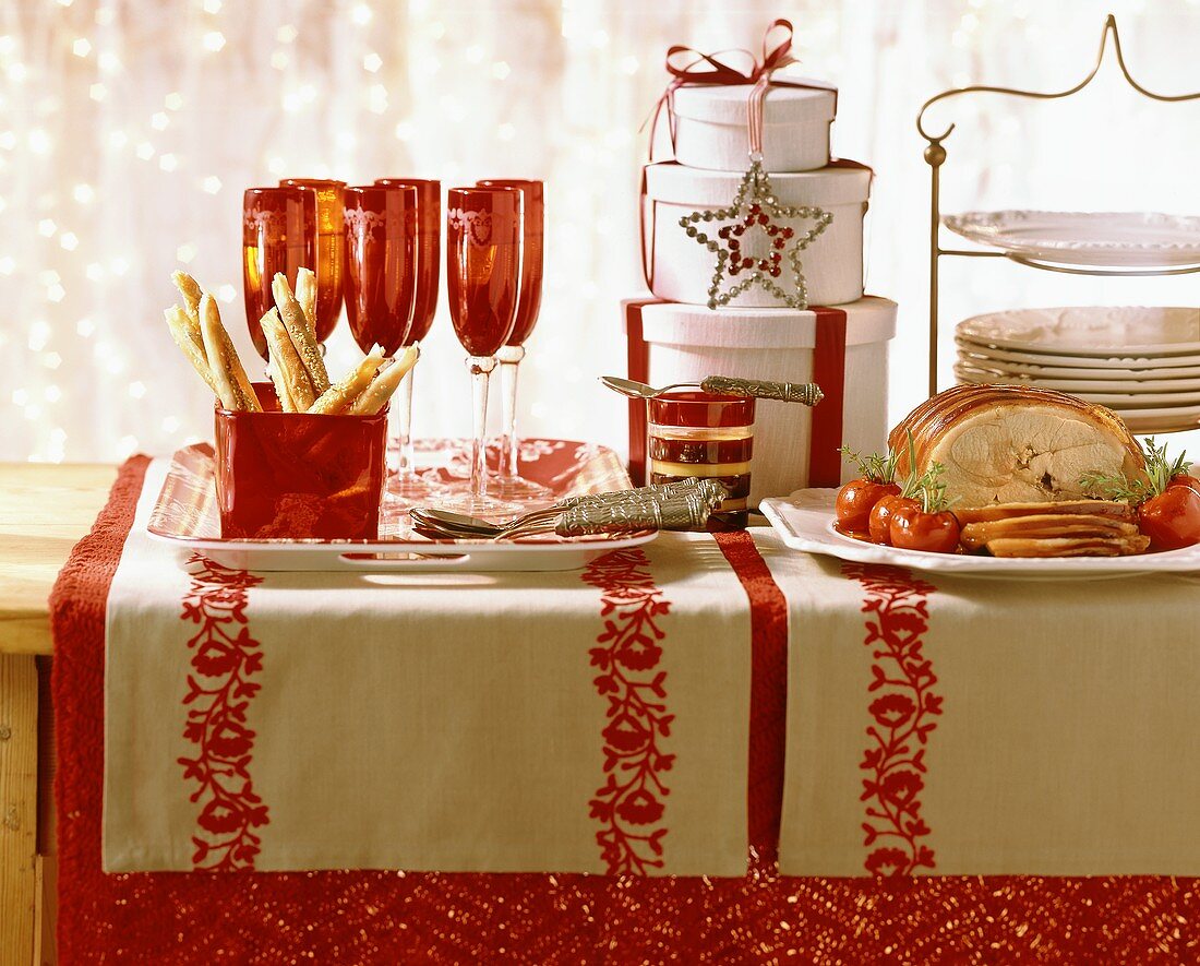 Table laid for Christmas in red and white with roast pork