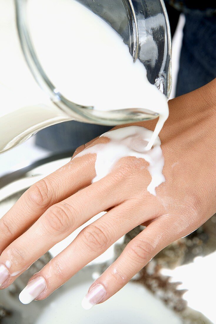 Milk running over a woman's hand