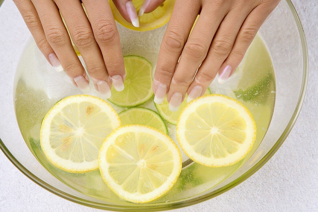 Frauenhände baden in Zitronenwasser
