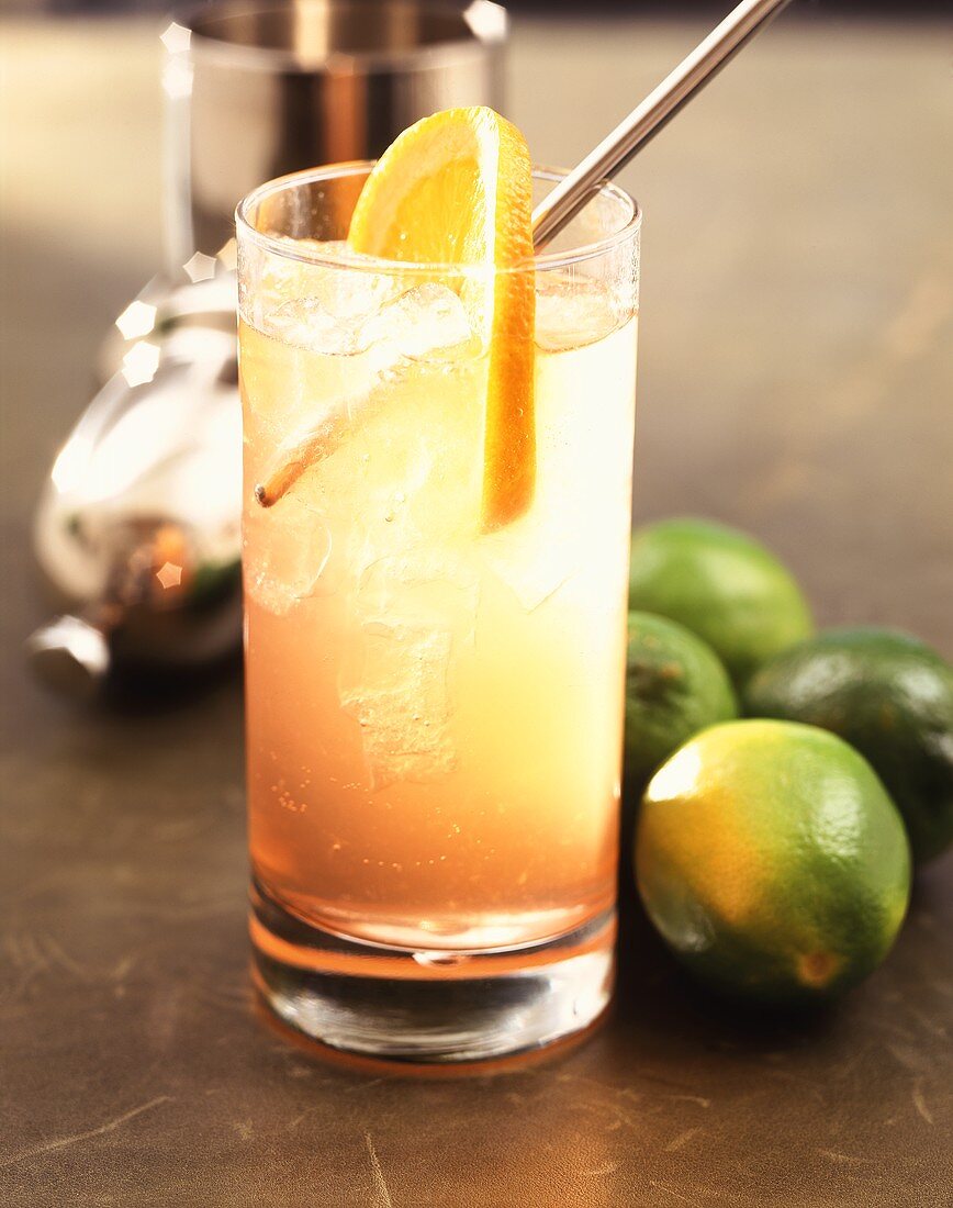 Orangen-Gin-Drink mit Limetten und Cocktailshaker