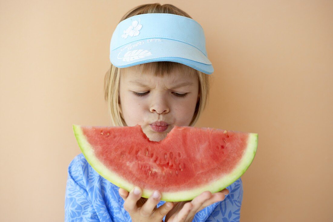 Mädchen hält angebissenen Melonenschnitz