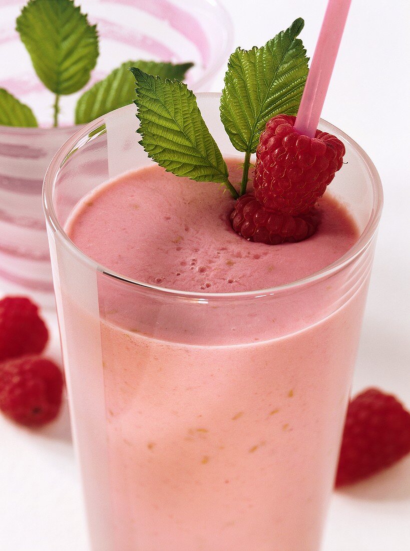 Raspberry milkshake in glass with straw