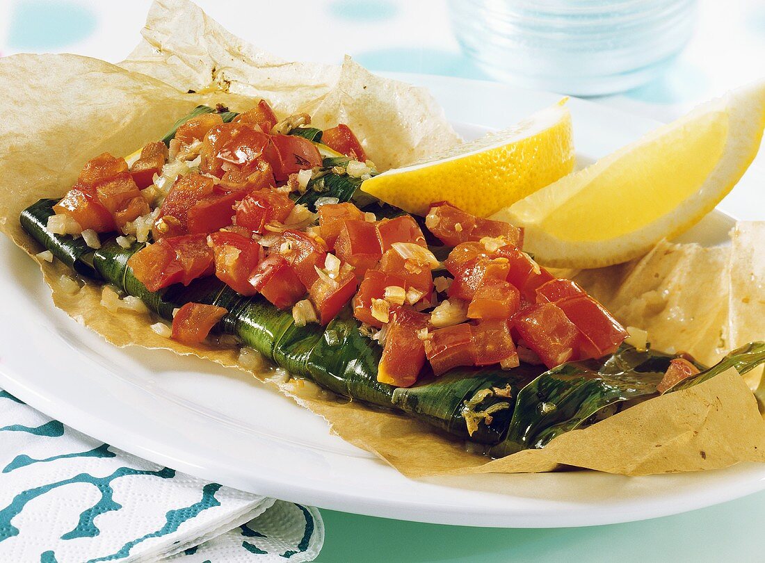 Fish wrapped in ramsons (wild garlic) with diced tomatoes