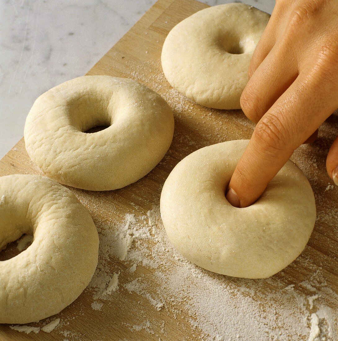 Making bagels: making holes in balls of dough