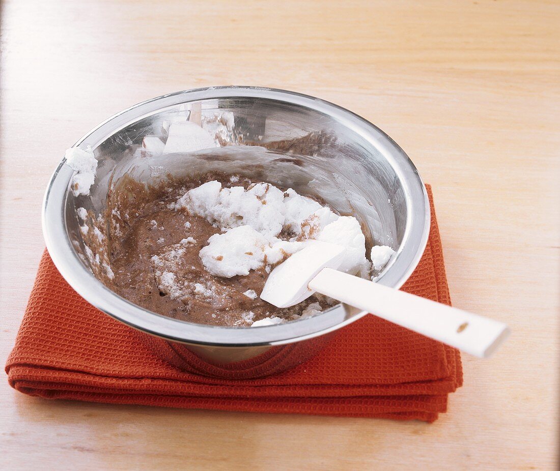 Making mocha soufflé: folding beaten egg white into cocoa mixture