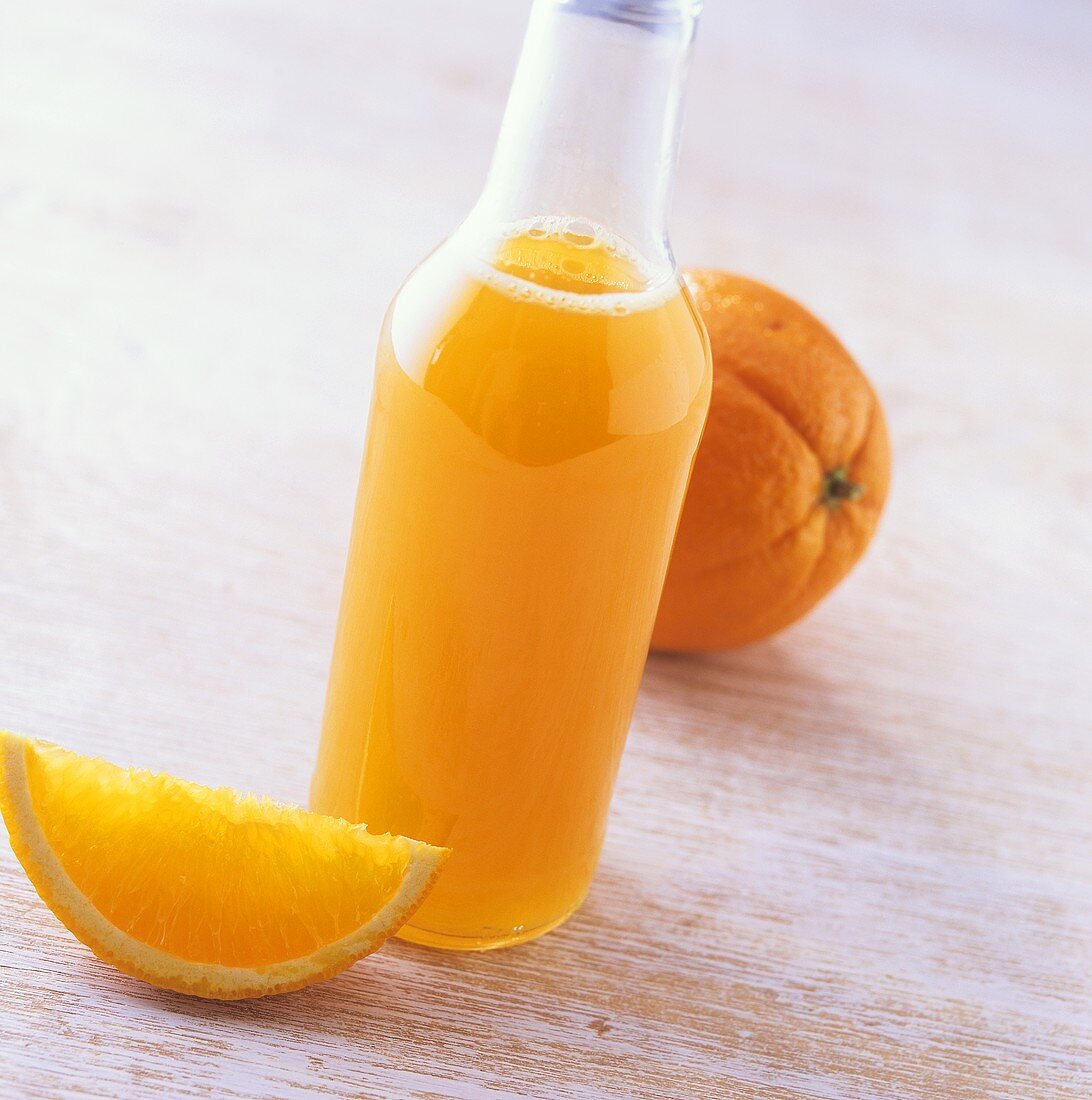 Flasche Orangensirup und frische Orangen