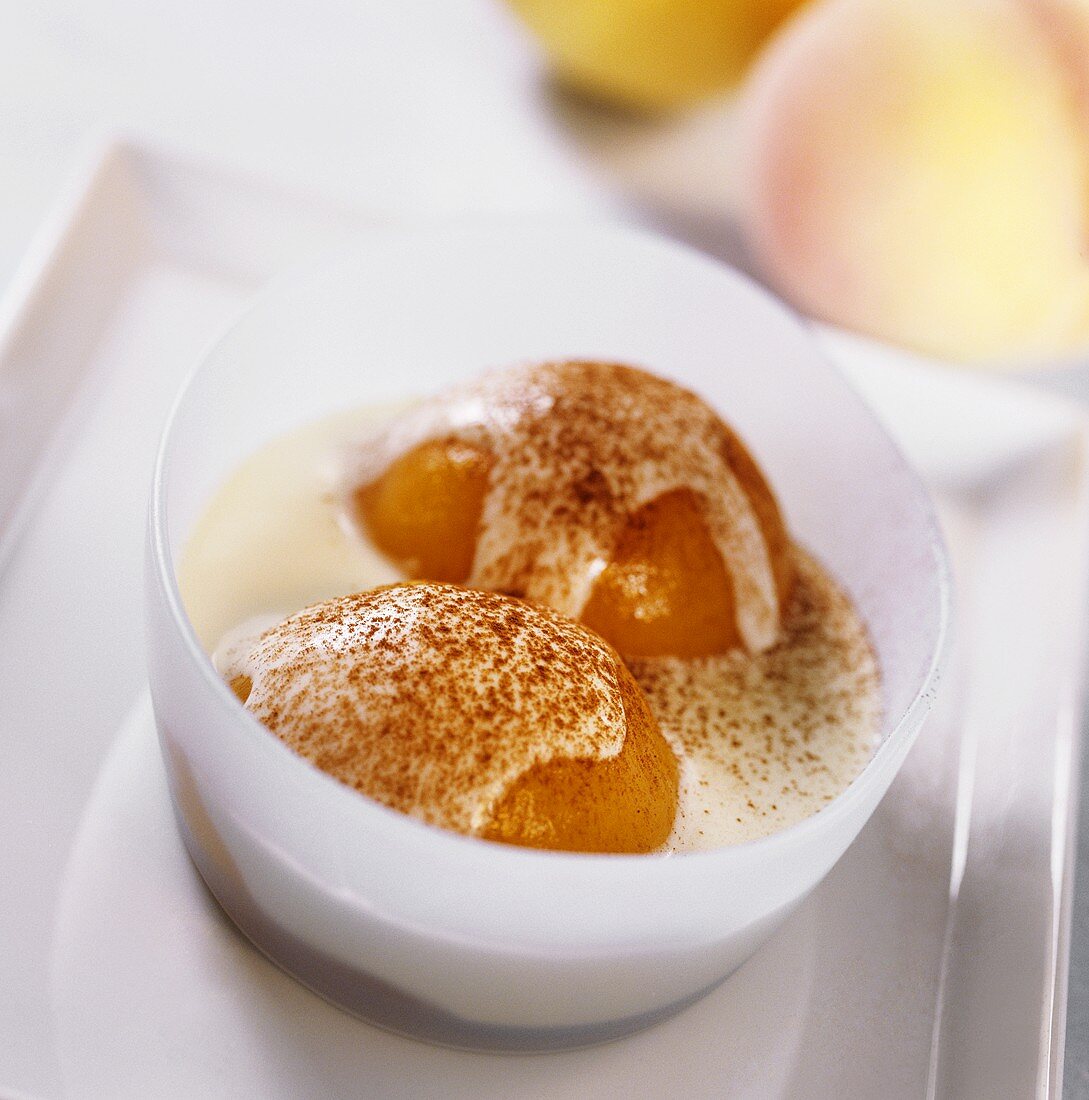 Poached peach in white wine sauce with cinnamon