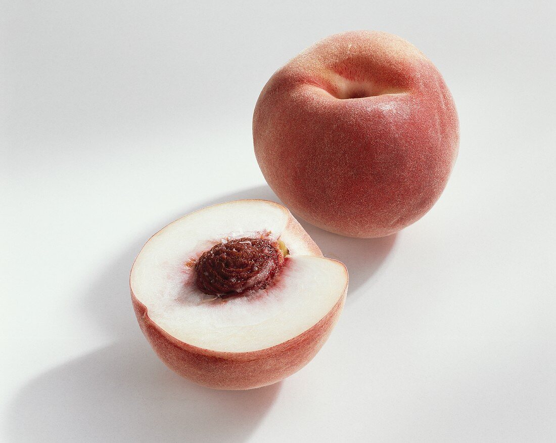 Pfirsich (Prunus persica), Sorte Snow King, ganz und halbiert