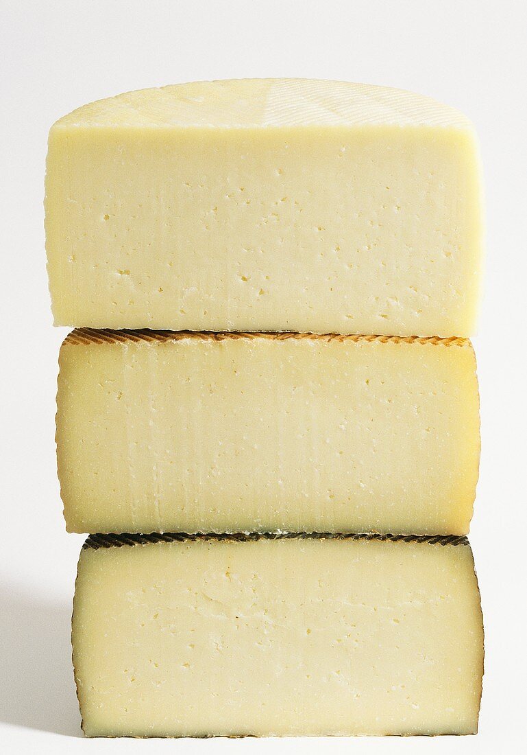 Manchego, cut in half, at three stages of maturity