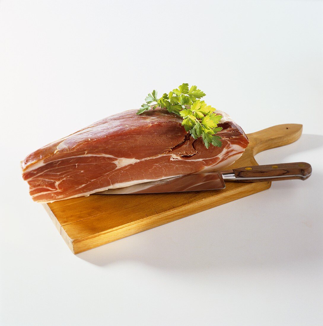 Raw Schinkenspeck ham on a wooden board