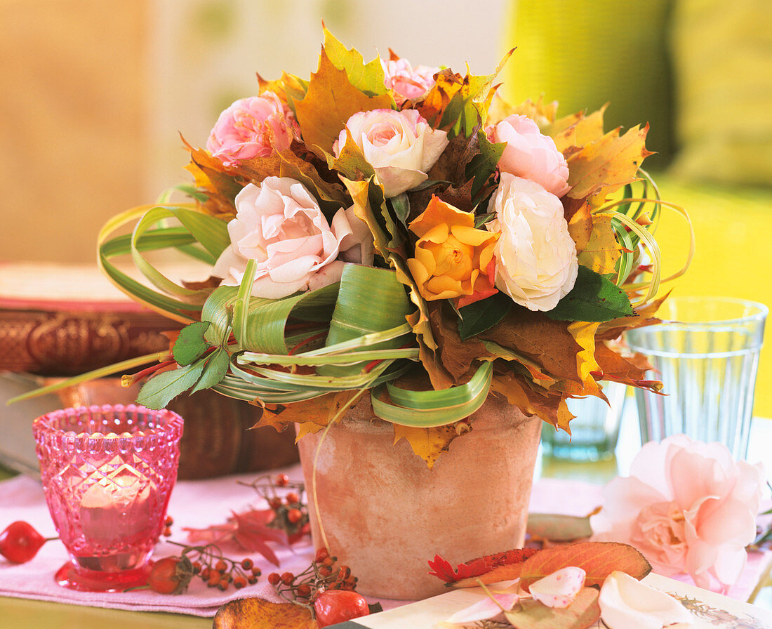 Autumn arrangement of roses, maple leaves and Chinese silvergrass