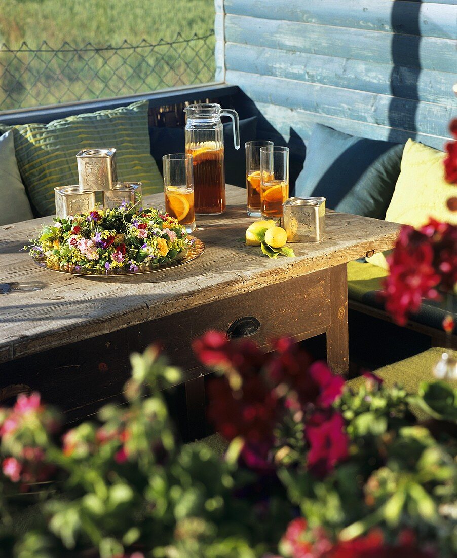 Eistee und Blumenkranz auf einem Holztisch