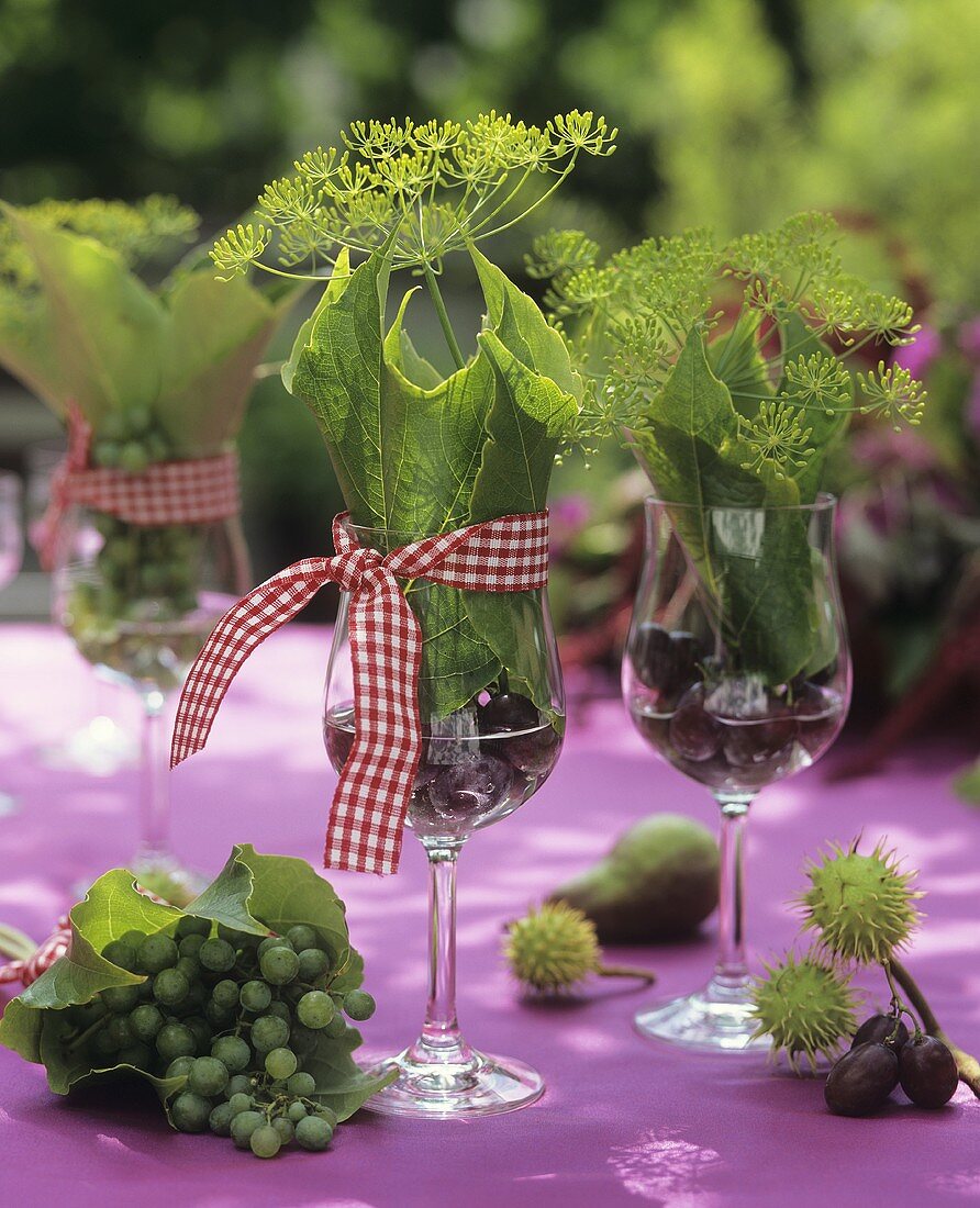 Tisch dekoriert mit Dill, Weinblättern und Kastanien