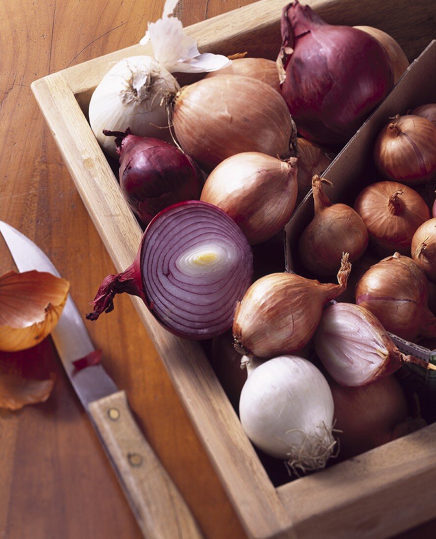 Various types of onions in wooden box