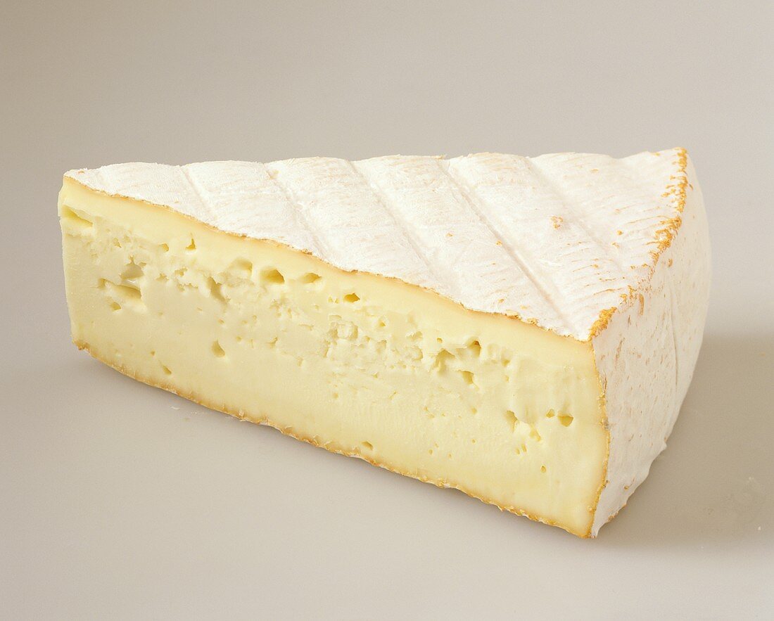 A piece of soft cheese with orange rind