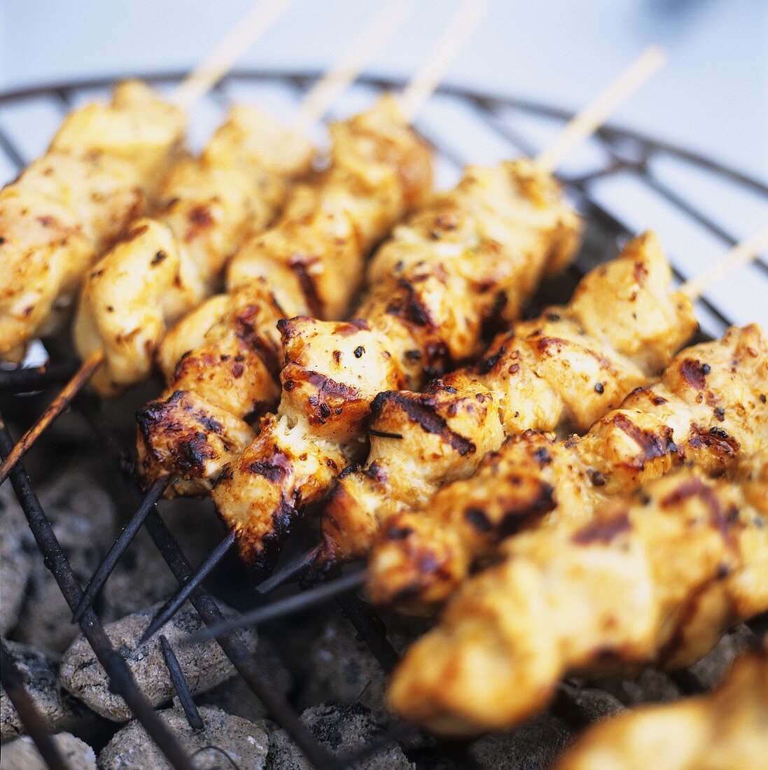 Barbecued chicken kebabs on a grill rack