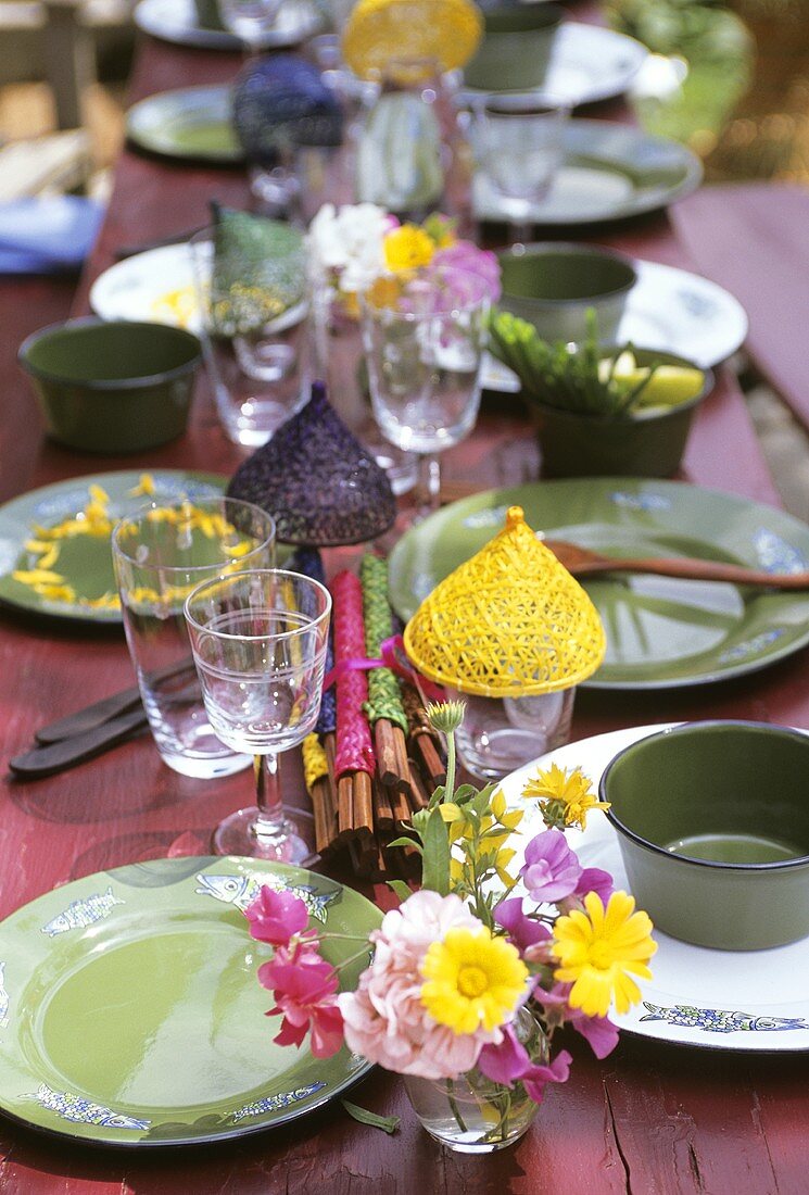 A table laid with green tableware in open air