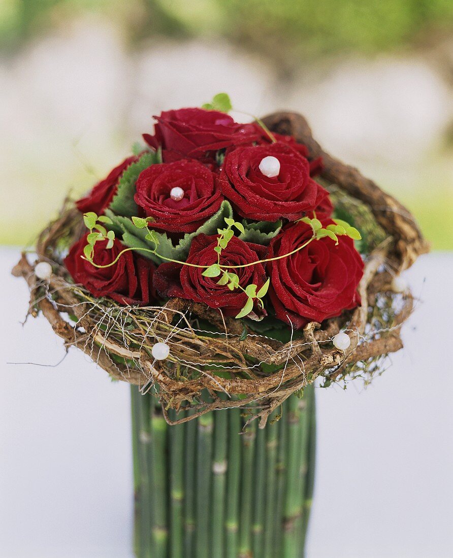 A bouquet of roses surrounded by a wreath of twigs