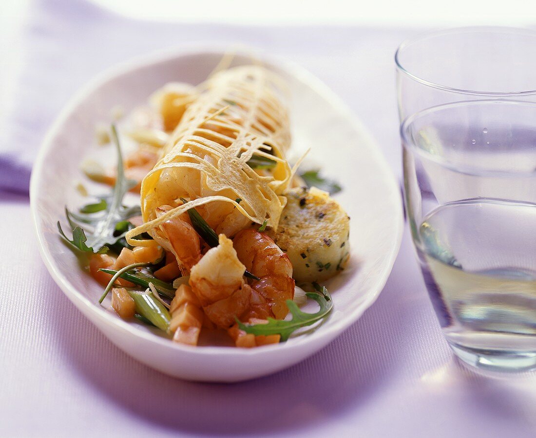 Salad with shrimps, potato cakes, and papayas in egg net