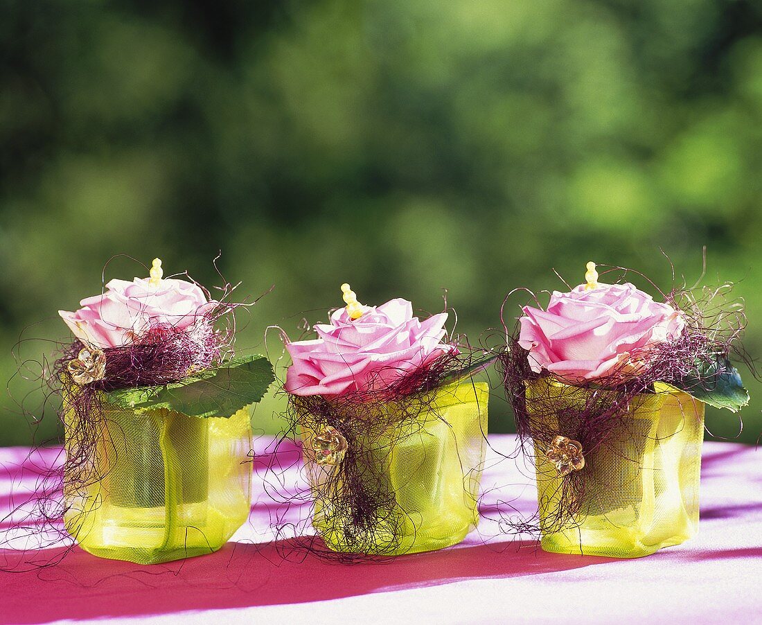 Three roses in decorated glasses