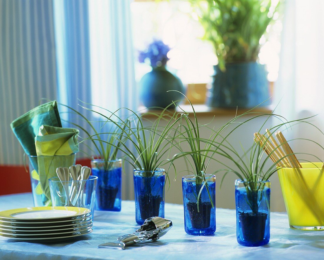 Vier blaue Gläser mit kleinen Elefantenfüssen als Tischdeko