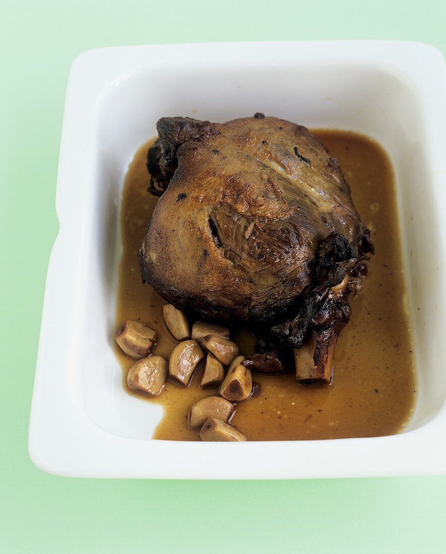 Leg of lamb in a roasting dish with garlic and sherry sauce