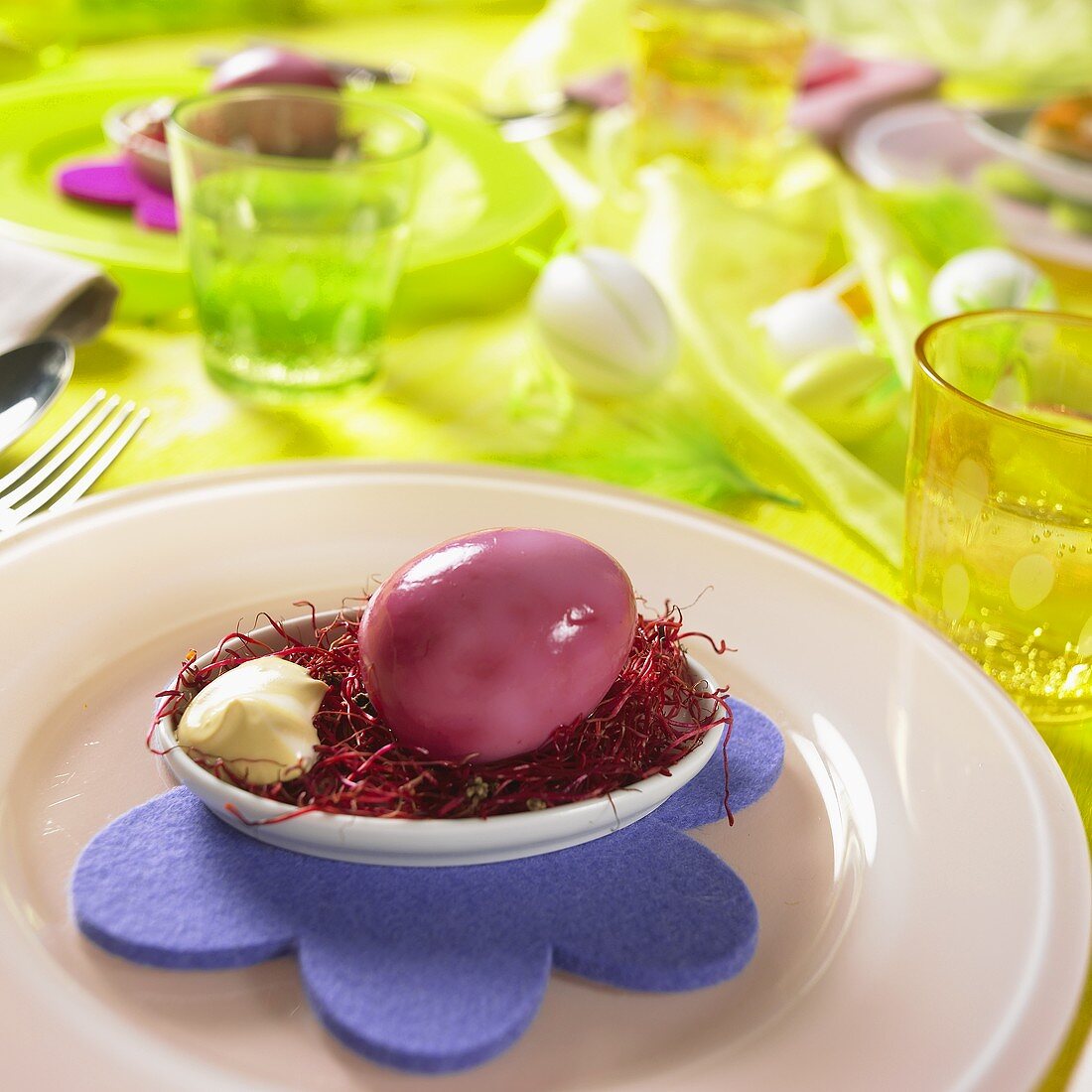 Purple marbled Easter egg in a bowl of mayonnaise